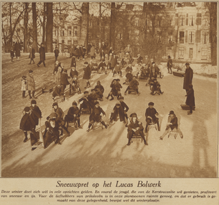871618 Afbeeling van een grote groep kinderen die met hun sleetje een helling op het Lucasbolwerk te Utrecht afglijden.